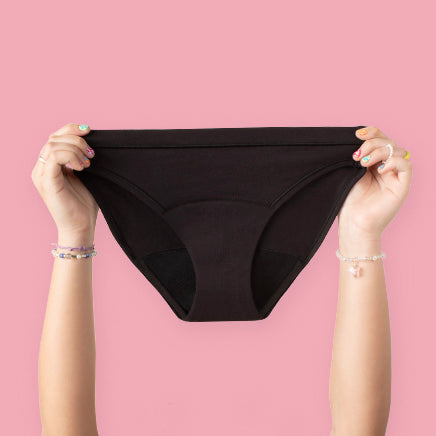 Two Hands Holding Up Black Teen Period Underwear