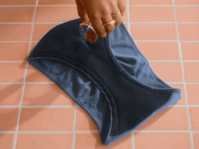 An animated gif showing liquid being poured into the gusset of Thinx for All showing the underwear's absorbent qualities.
