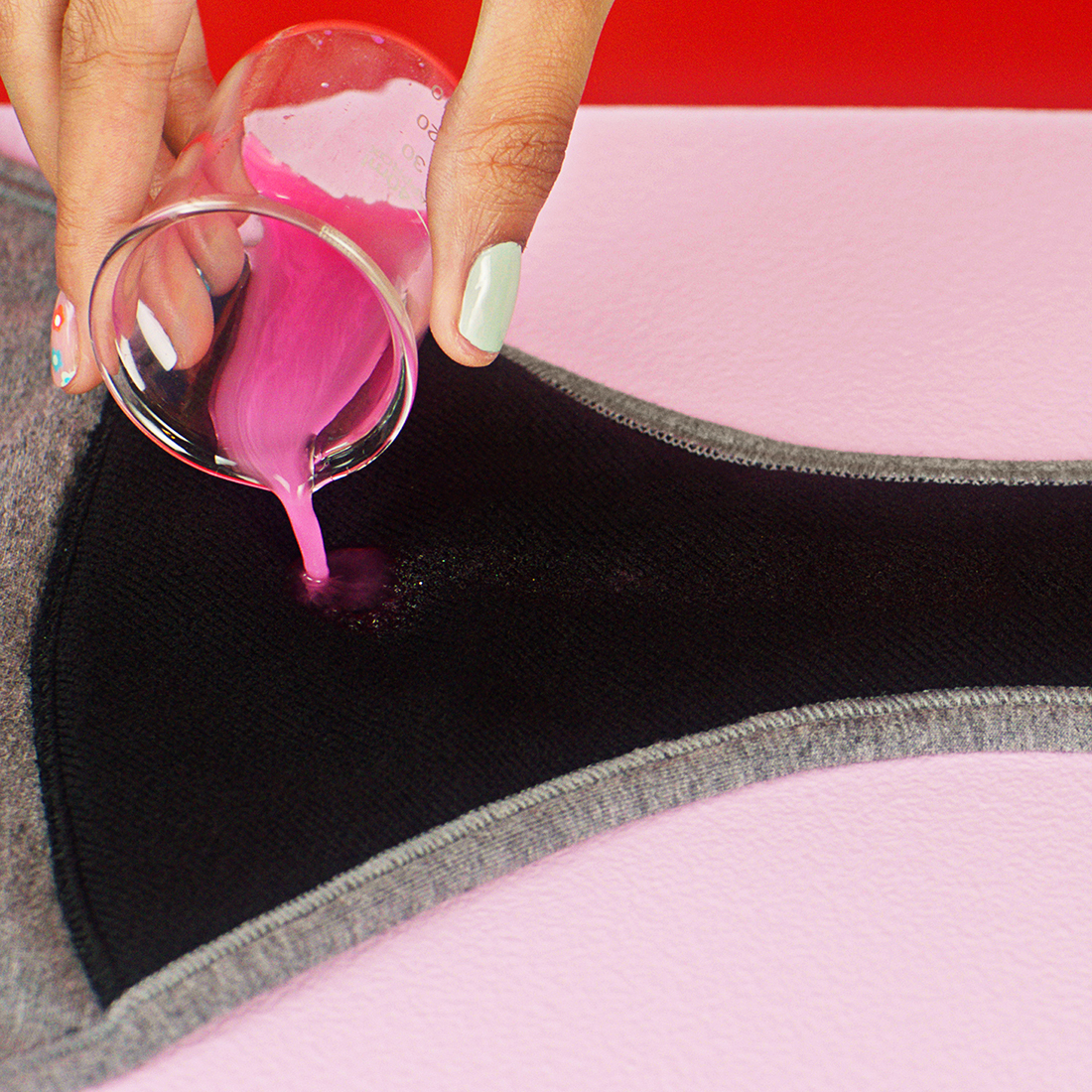 pink liquid being poured into a Thinx Teens gusset